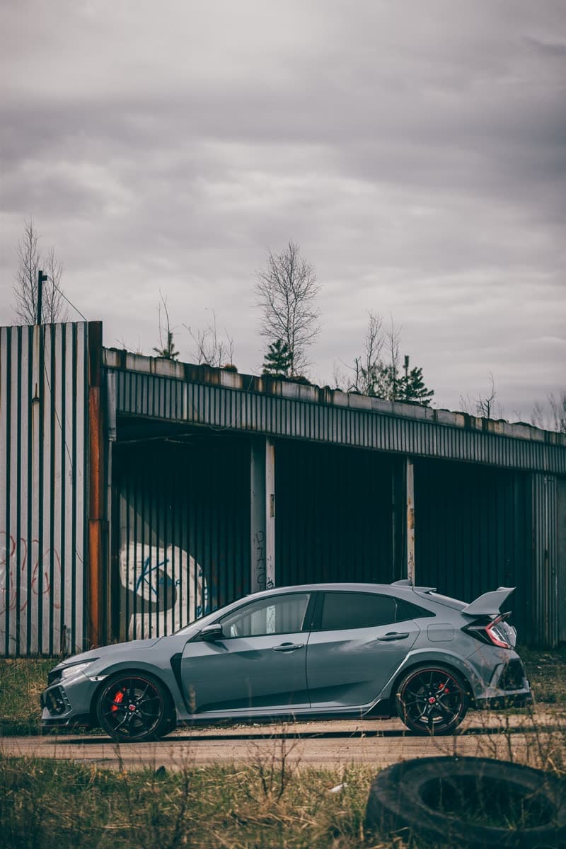 Black Honda Civic Type R beside a warehouse